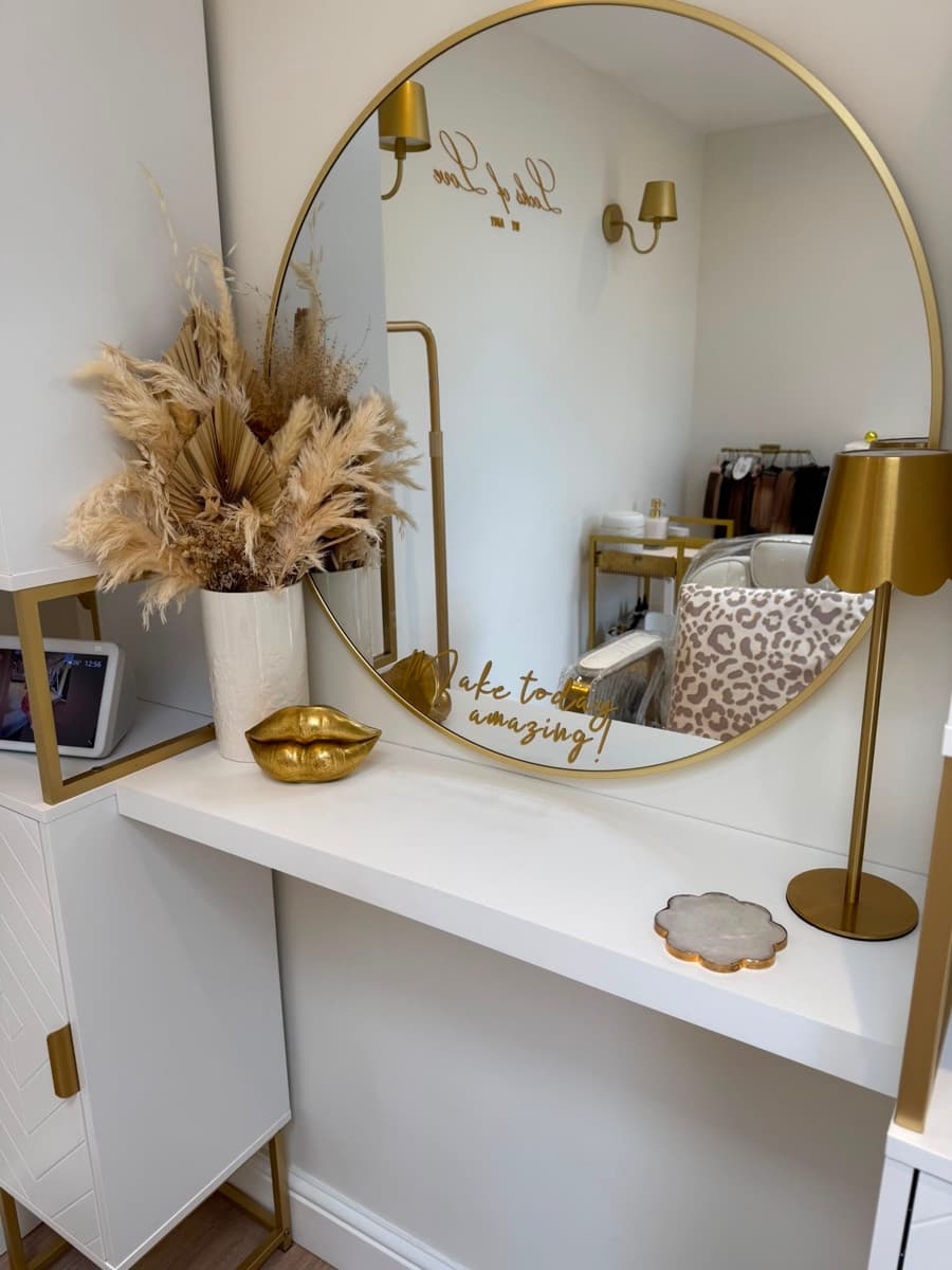 The styling station at Amy's Stevenage studio, with a round gold mirror, dried pampas and a Locks of Love by Amy decal